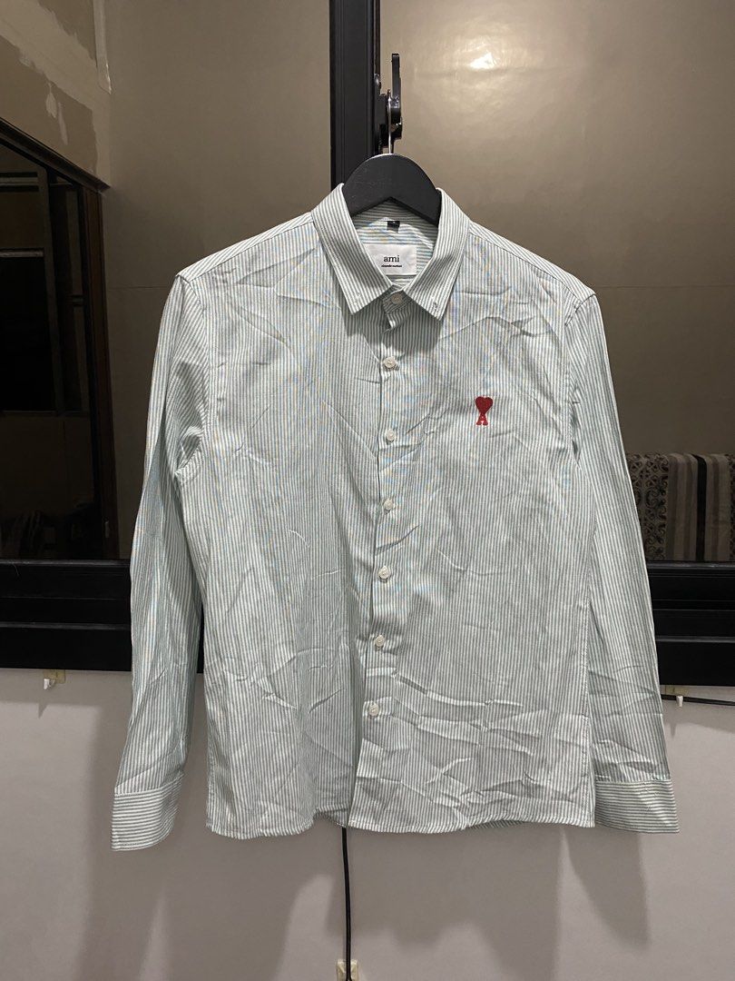 Ami Paris Striped Button Down Shirt Size S (Category: Tshirts & Polo Shirts ) located in Manila. Submitted by hell_market (Listing ID 1466925586, Image 1). Description: - Brand: Ami Paris - Style: Long-sleeve button-down shirt with green and white vertical stripes - Detail: Signature embroidered small red heart logo on the chest - Size: Small (tag attached inside collar) - Material: 100% organic cotton, made in Portugal - Features: Standard colla