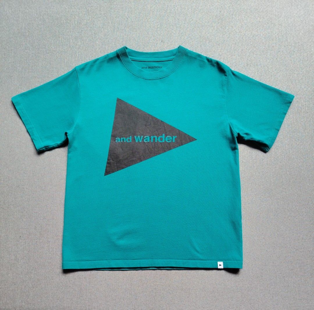 And Wander Big Logo Shirt (Category: Tshirts & Polo Shirts ) located in Taguig. Submitted by _theroom.ph (Listing ID 1466838101, Image 1). Description: - Brand: and wander - Color: Bright turquoise / teal - Design: Large triangle graphic on front with branding - Details: Branded inside collar with quote text, Tokyo brand tag on inner hem - Fit: Classic crew neck with short sleeves - Condition: Excellent And Wander Big Logo Shirt 24.5 x 19.5 Small