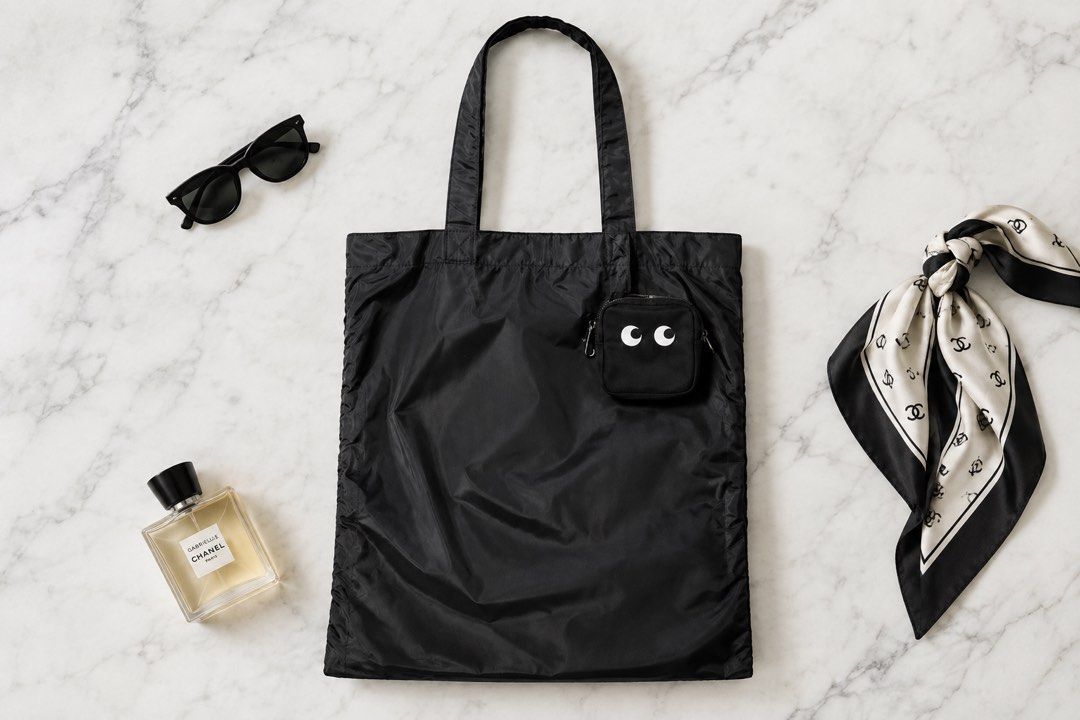 Anya Hindmarch x Uniqlo Packable Tote (Category: Luxury Bags & Wallets) located in Cebu City. Submitted by relovedfinds.ph (Listing ID 1466784043, Image 1). Description: This stylish black bag is made from lightweight nylon with solid construction and clean stitching for a sleek, everyday look. It features dual shoulder straps with trendy gathered side details, adding a chic touch to its simple design. The spacious interior provides plenty of roo