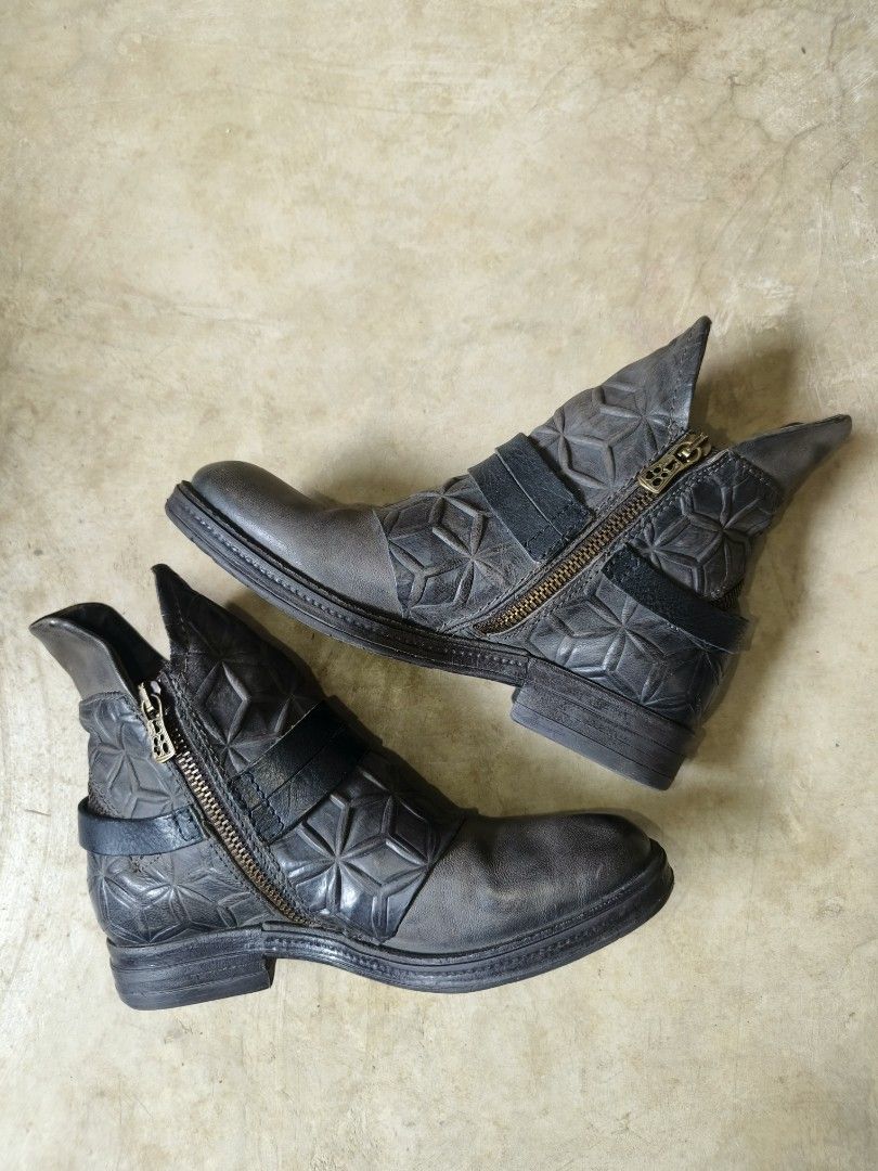 A.S 98 Archival post apocalyptic leather boots (Category: Boots) located in Davao. Submitted by vndrgd (Listing ID 1466782866, Image 2). Description: - Grey leather ankle boots with unique geometric quilted pattern - Double side straps with large brass buckle detail - Convenient side zipper closure with matching brass hardware - Contrasting dark grey toe cap and low heel - Sturdy rubber sole for durability and comfort.
