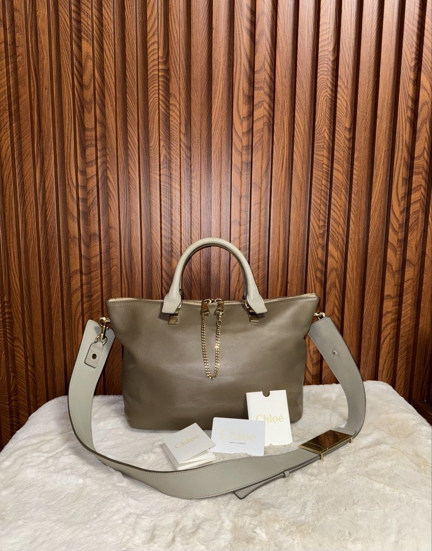 Authentic Chloé Baylee Medium Leather Satchel Bag (Category: Luxury Bags & Wallets) located in Subic. Submitted by luxshoppe88 (Listing ID 1466876149, Image 2). Description: Chloé Baylee satchel in grey leather. Dual top handles and a wide shoulder strap. Gold-tone hardware with chain detail linking the dual top zippers. Brown fabric lining inside with zipper and slip pockets. Flat bottom base. Includes authentication cards and tags as pictured. 