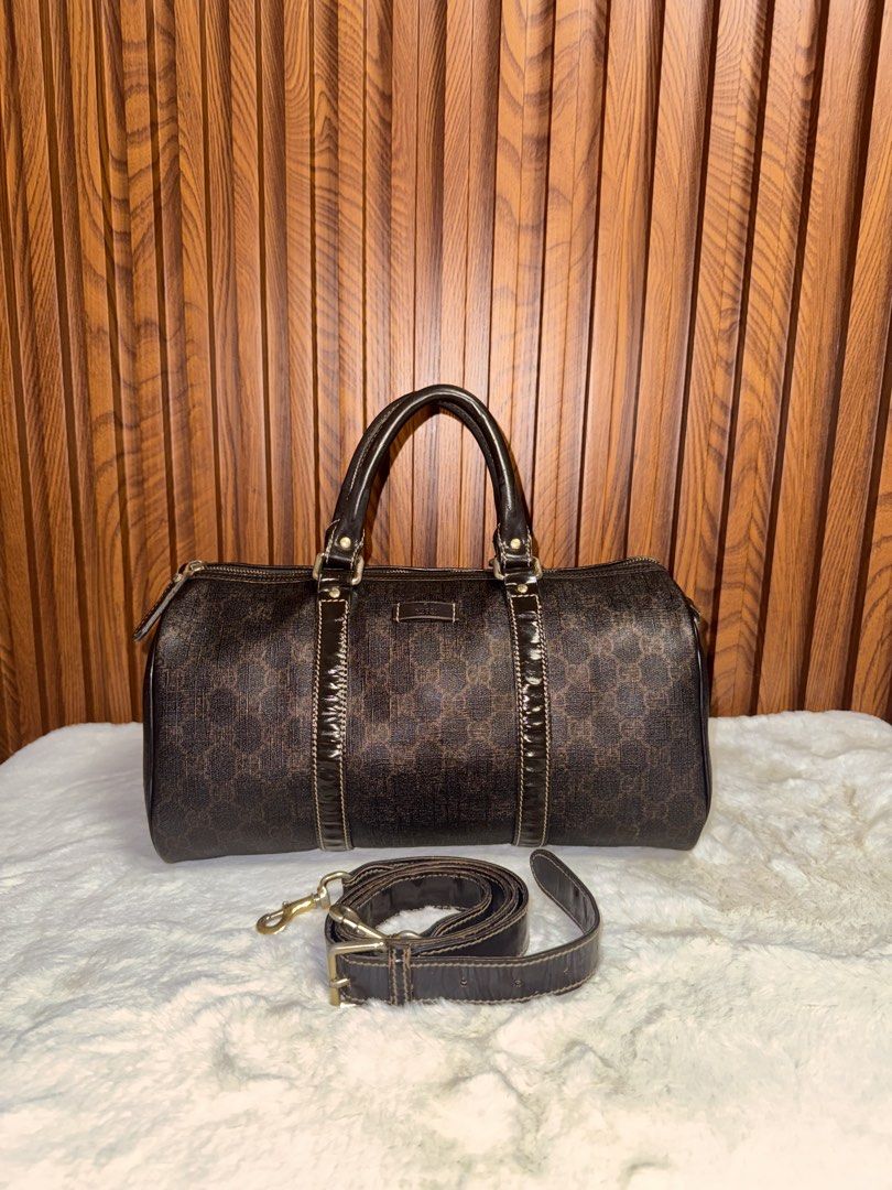 Authentic Gucci Monogram Boston Bag with Strap (Category: Luxury Bags & Wallets) located in Subic. Submitted by luxshoppe88 (Listing ID 1466877644, Image 1). Description: - Authentic Gucci dark brown monogram Boston bag - Durable textured canvas finish with structured patent leather trim and handles - Secure zip top closure with spacious everyday interior - Includes matching adjustable leather shoulder strap with gold-tone hardware - Convenient s