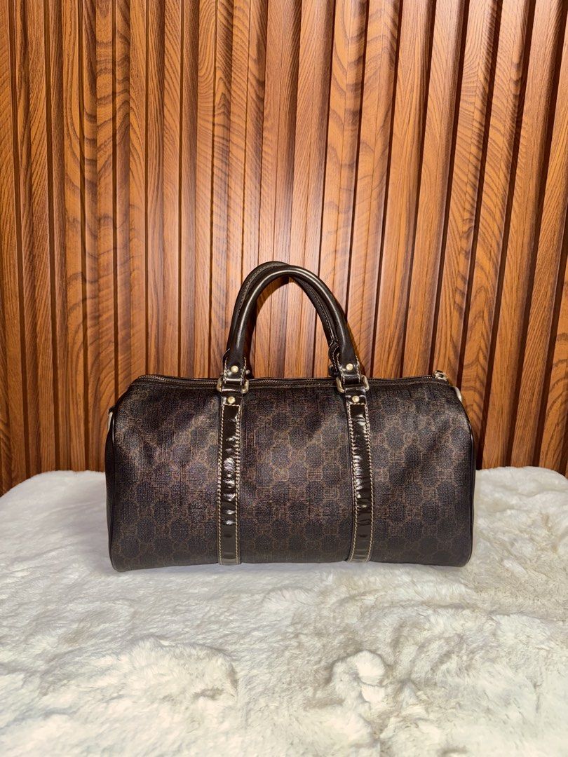 Authentic Gucci Monogram Boston Bag with Strap (Category: Luxury Bags & Wallets) located in Subic. Submitted by luxshoppe88 (Listing ID 1466877644, Image 2). Description: - Authentic Gucci dark brown monogram Boston bag - Durable textured canvas finish with structured patent leather trim and handles - Secure zip top closure with spacious everyday interior - Includes matching adjustable leather shoulder strap with gold-tone hardware - Convenient s