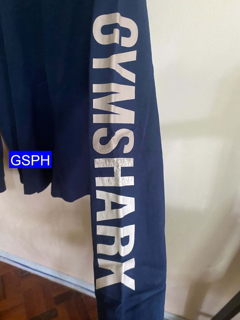 Authentic Gymshark Navy Long Sleeve (Category: Activewear) located in Makati City. Submitted by goodiesstuff_ph_17119811 (Listing ID 1466860736, Image 2). Description: Bought this on Gymshark application ROW, shipped from Belgium. The size is XS but it was an adult US-EU standard size. For Filipino like me the size is too big, worn this only three times. - Brand: Gymshark - Color: Navy blue - Design: Graphic box logo on chest, large lettering on 