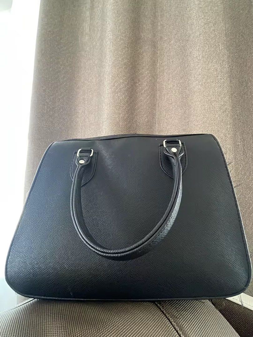 Authentic Marikina Bag (Category: Tote Bags) located in Cavite. Submitted by t_m_jazmin (Listing ID 1466916543, Image 2). Description: - Color/Material: Black textured leather - Hardware: Silver-tone details - Straps: Dual top handles and a detachable long shoulder strap - Design: Structured rectangular shape with rounded bottom corners - Interior: Clean lining with secure zip closure - Capacity: Spacious enough to fit your daily essentials easil