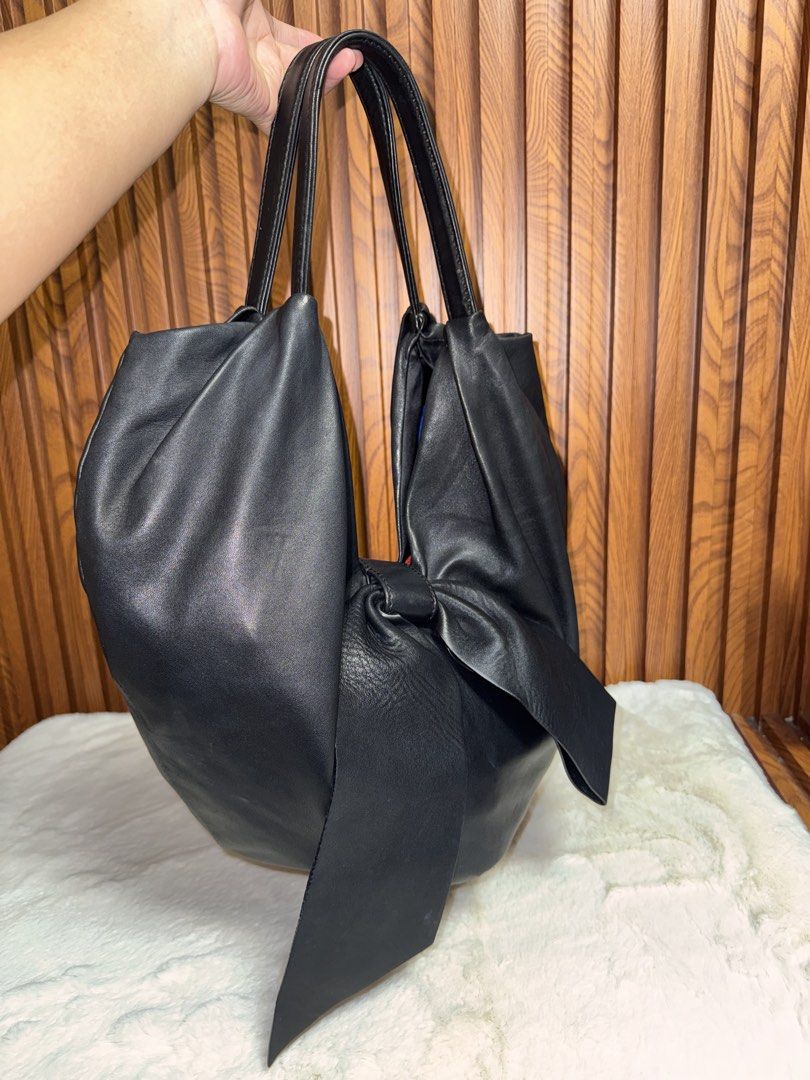 Authentic Valentino Black Leather Bow Tote Handbag (Category: Luxury Bags & Wallets) located in Subic. Submitted by luxshoppe88 (Listing ID 1466877441, Image 2). Description: Authentic Valentino black leather handbag featuring dual top handles, a chic front bow, and silver-tone logo hardware. The open-top design reveals a spacious textile interior complete with a zipper pocket and slip compartments. Soft, luxurious leather in a versatile deep bla