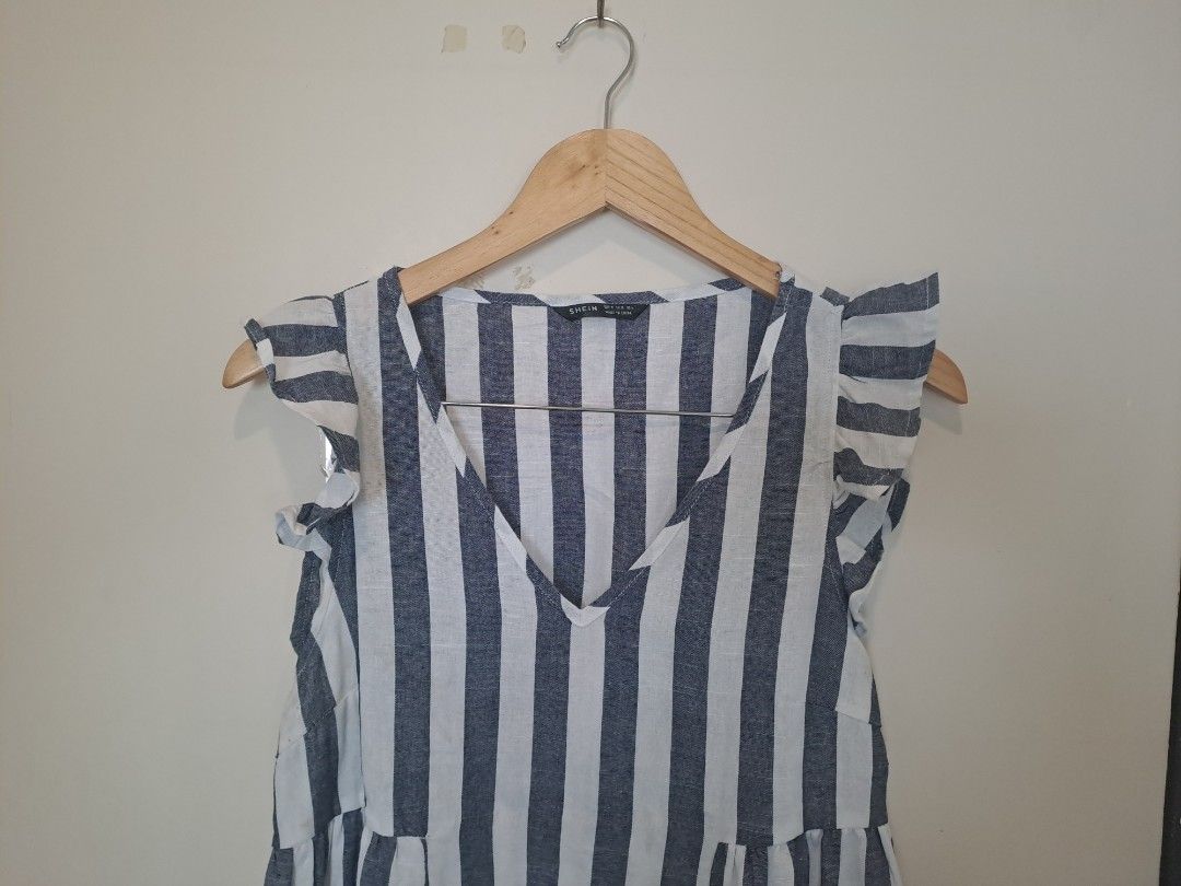 Babay doll sleeveless (Category: Sleeveless) located in Manila. Submitted by joanbalde39643 (Listing ID 1466837827, Image 2). Description: The item featured is a blue and white vertically striped babydoll top from the brand SHEIN. It features a flattering V-neckline, short ruffed/flounce sleeves, and an empire waist that flows out into a relaxed bodice..