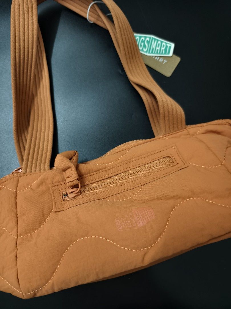 BAGSMART Quilted Orange Shoulder Bag (Category: Shoulder Bags) located in Angeles City. Submitted by measaliman02351 (Listing ID 1466882967, Image 2). Description: - Brand: BAGSMART - Color: Vibrant orange - Material: Soft puffed nylon with trendy wave stitch pattern - Handles: Dual ribbed top handles for comfortable carrying - Pockets: Convenient front zip pocket with pull tab and embossed logo patch - Closure: Secure main zip closure across the