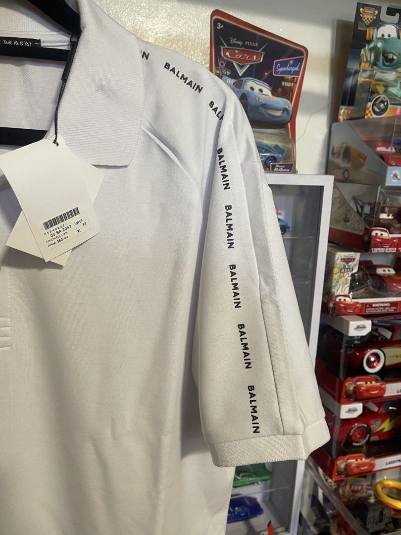 Balmain White Logo Polo Shirt (Category: Tshirts & Polo Shirts ) located in Manila. Submitted by thenotoriusthrift (Listing ID 1466778569, Image 2). Description: Brand: Balmain Color: Crisp White with Contrast Black Logo Tape Condition: Brand New with Original Hang Tags (Not a thrifted item) Size: 23 by 29 (XL) .