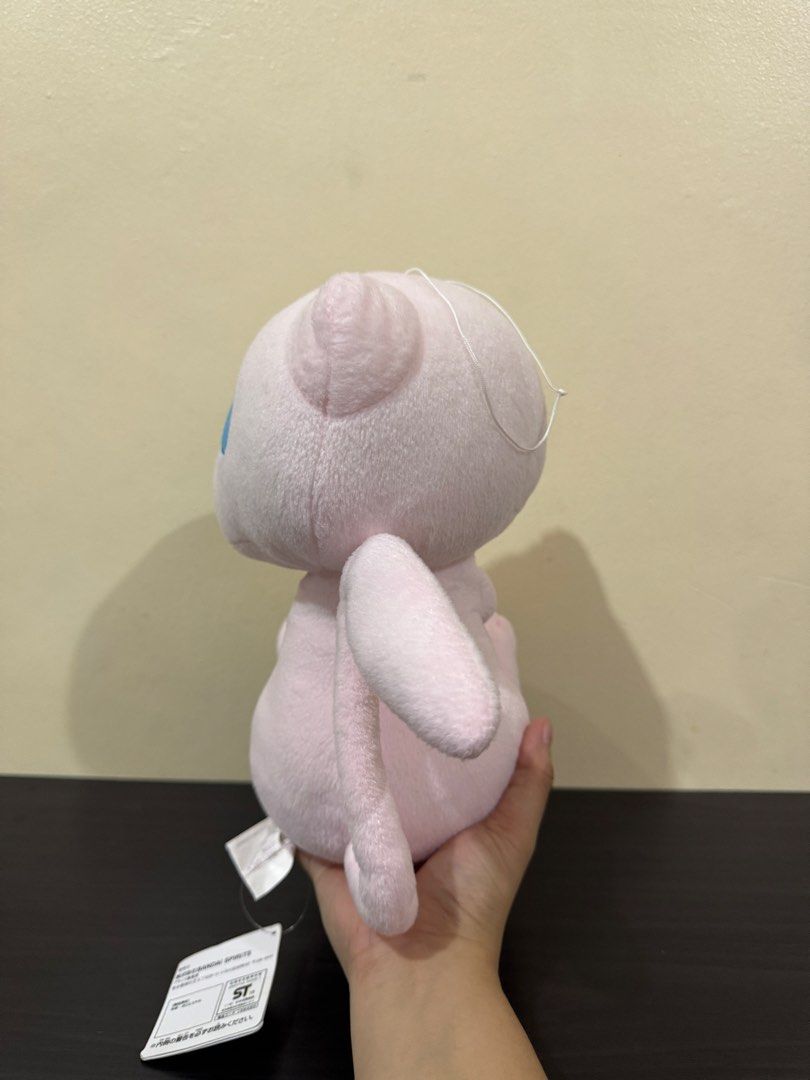 Bandai Spirits Pokémon Mew Plush Toy (Category: Plushies & Soft Toys) located in Cainta. Submitted by mayhroeen (Listing ID 1466966424, Image 3). Description: - Official Banesto prize item by Bandai Spirits (Made in Vietnam) - Features soft pink fabric, cute embroidered blue eyes, and stitched paws - Includes attached paper hang tag and purple tush tag - Built-in white loop string at the top for easy hanging - Condition: Clean and well-maintained
