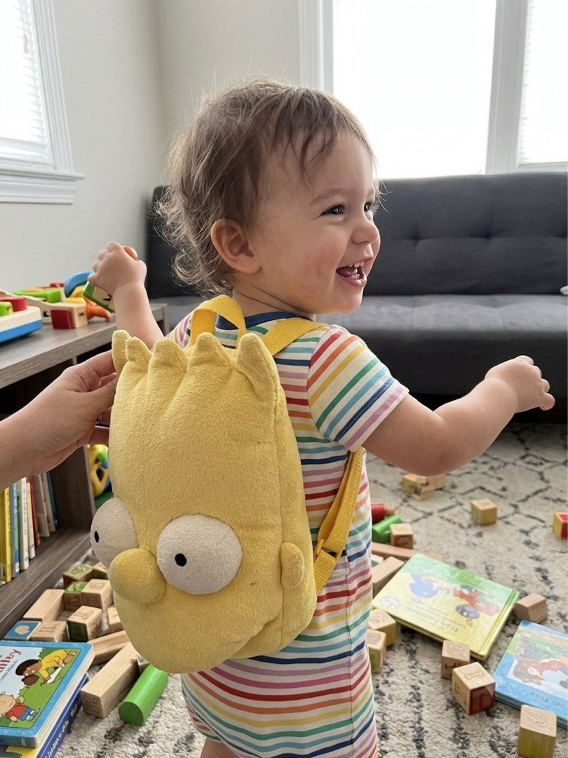 Bart Simpson plush backpack yellow cartoon bag (Category: Babies & Kids Fashion) located in Los Banos. Submitted by italiangoodies (Listing ID 1466943562, Image 3). Description: - Eye-catching bright yellow Bart Simpson plush backpack - Made from super soft and fuzzy material - Features iconic spiky hair and big white eyes on the front - Adjustable yellow straps with buckle closure for a comfortable fit - Top zipper opening with some minor staini