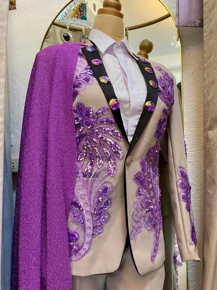 Beige suit with purple sequins and cape (Category: Coats, Jackets and Outerwear) located in Dasmarinas. Submitted by sagalagown66473 (Listing ID 1466797493, Image 2). Description: - Style: Custom performance wear, stage outfit, or costume - Color/Design: Beige suit with vibrant purple sequin appliqués, floral embroidery, and black-lined lapels - Details: Large iridescent rhinestone buttons - Included Items: Matching trousers, white collared shirt