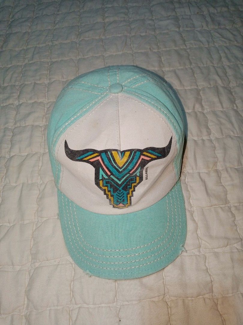 Billabong Turquoise Bull Skull Cap Hat One Size (Category: Caps & Hats) located in Allen. Submitted by milyonaryung_gipit (Listing ID 1466793596, Image 1). Description: Billabong cap in turquoise and white canvas. Bull skull graphic printed across the front panel with colorful geometric details. White contrast stitching along the panels and brim. Made of 100 percent cotton. Adjustable back strap with fabric label tag. Spot clean only per the inne