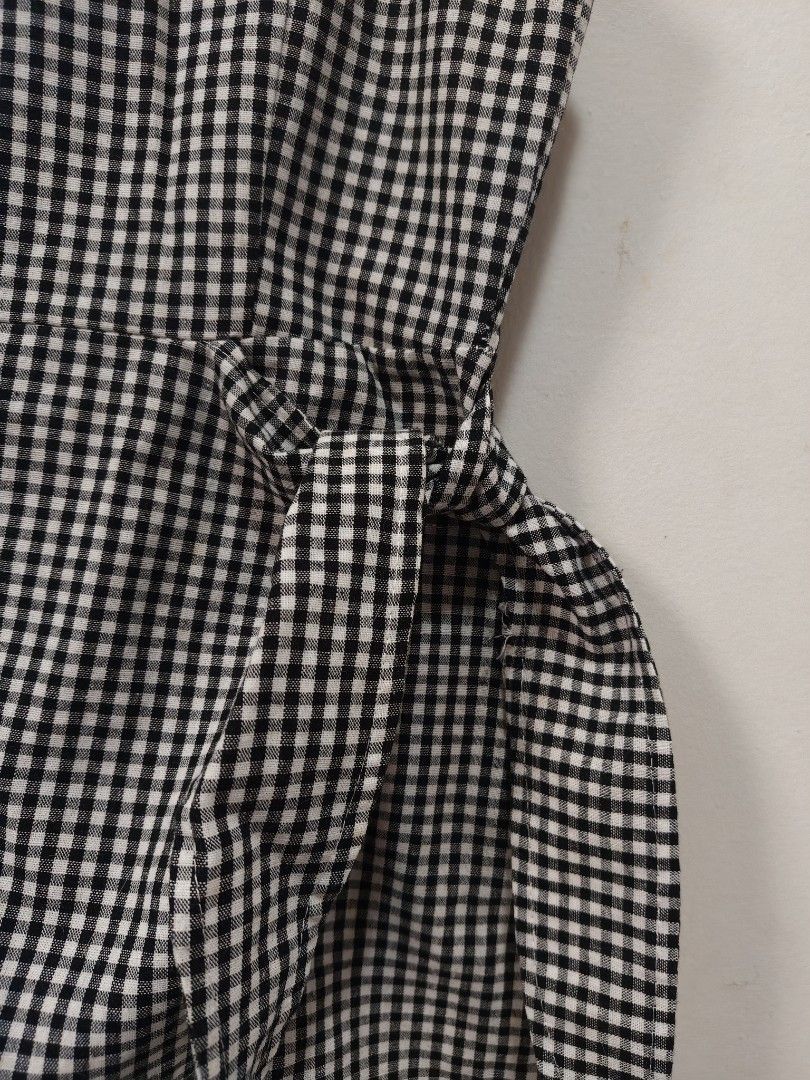 Black and white gingham spaghetti strap romper (Category: Rompers) located in Antipolo. Submitted by _suspiria (Listing ID 1466778412, Image 2). Description: - XXS to XS - Not stretchy - Black and white checkered gingham romper with wrap skirt overlay - Design: Thin spaghetti straps, square neckline, and attached side waist tie-wrap - Comfort: Built-in shorts underneath, made from lightweight fabric - Fit: Measures roughly 13 inches across the wa