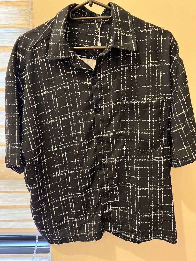 Black and White Grid Pattern Short Sleeve Shirt (Category: Shirts) located in Las Pinas. Submitted by basicapparel_mnl (Listing ID 1466968578, Image 1). Description: - Style: Camp collar short sleeve button-down - Design: Black with white dashed grid print - Details: Single left chest pocket, front button closure - Fit: Relaxed and lightweight - Condition: Brand new with tag attached.