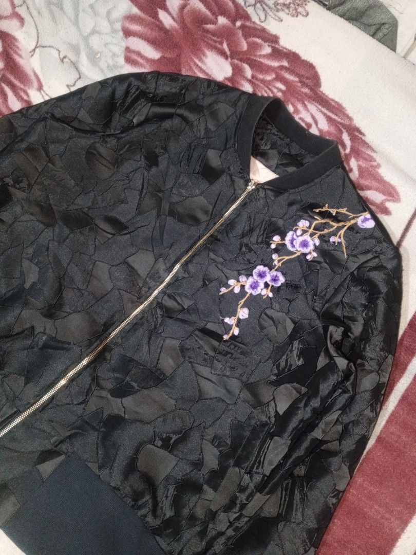 Black bomber jacket with floral embroidery (Category: Coats, Jackets and Outerwear) located in Baguio. Submitted by tyrontoler83676 (Listing ID 1466933957, Image 2). Description: - Color: Classic black - Design: Textured geometric pattern all over - Details: Eye-catching purple cherry blossom embroidery on the left chest - Hardware: Premium gold-tone front zip-up closure - Fit/Trim: Comfortable ribbed black cuffs and hem - Condition: Clean overal