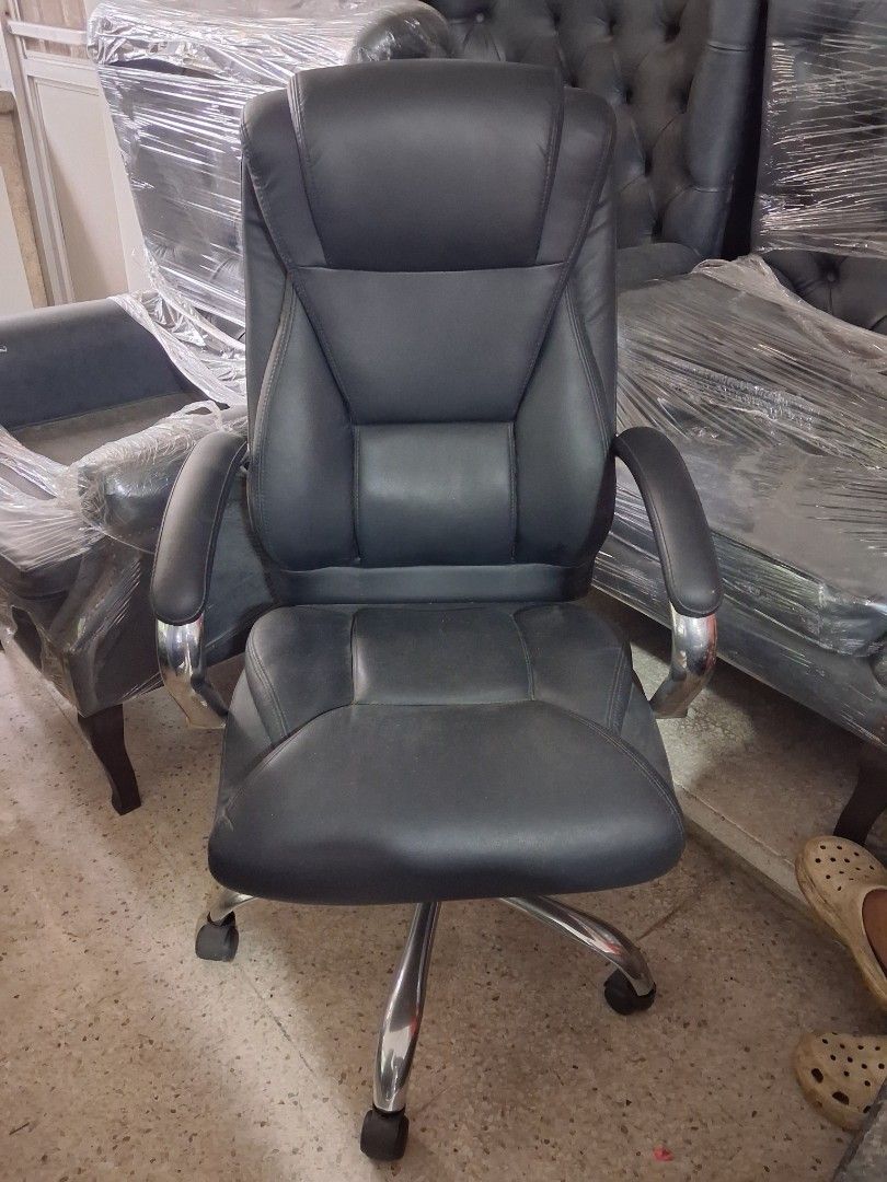 Black ergonomic executive office chair with chrome base (Category: Office Furniture & Fixtures) located in Quezon City. Submitted by ssvcn (Listing ID 1466797530, Image 2). Description: - Sleek black leather office chair built for long work hours - Extra-thick padded seat, backrest, and armrests for maximum comfort - Durable chrome metal finish on armrests and sturdy five-star rolling base - Smooth adjustable height lever for custom positioning -