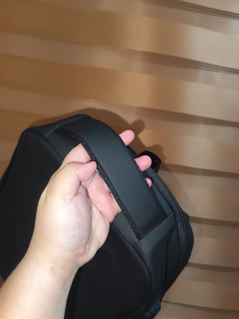 Black geometric hard-shell laptop backpack with multiple compartments (Category: Backpacks) located in Naga. Submitted by semflewer (Listing ID 1466832828, Image 3). Description: - Sleek black minimalist design with a structured geometric front panel - Comfortable daily wear with padded mesh back straps and back panel - Secure hidden zippered pocket on the back for valuables - Deep main compartment with practical side pockets - Reinforced top han