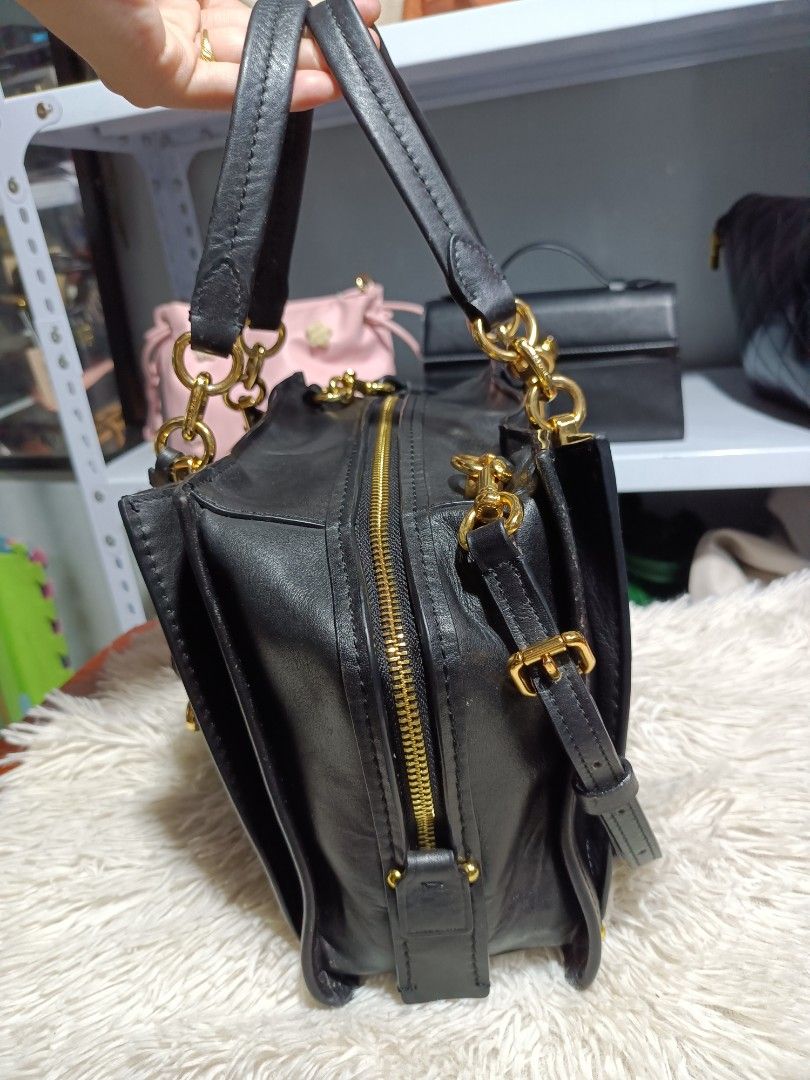 Black Leather Handbag with Gold Hardware (Category: Luxury Bags & Wallets) located in Naga. Submitted by zksboutique (Listing ID 1466779465, Image 3). Description: - Color & Material: Classic black leather with shiny gold hardware - Design: Structured shape with sleek metal bars on the front - Carry Options: Double top handles and a long adjustable shoulder strap - Closure: Secure top zipper closure - Interior: Multiple compartments for easy orga