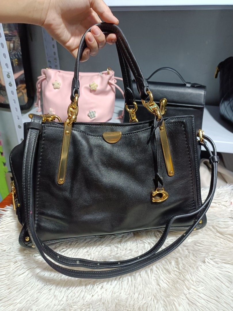 Black Leather Handbag with Gold Hardware (Category: Luxury Bags & Wallets) located in Naga. Submitted by zksboutique (Listing ID 1466779465, Image 1). Description: - Color & Material: Classic black leather with shiny gold hardware - Design: Structured shape with sleek metal bars on the front - Carry Options: Double top handles and a long adjustable shoulder strap - Closure: Secure top zipper closure - Interior: Multiple compartments for easy orga