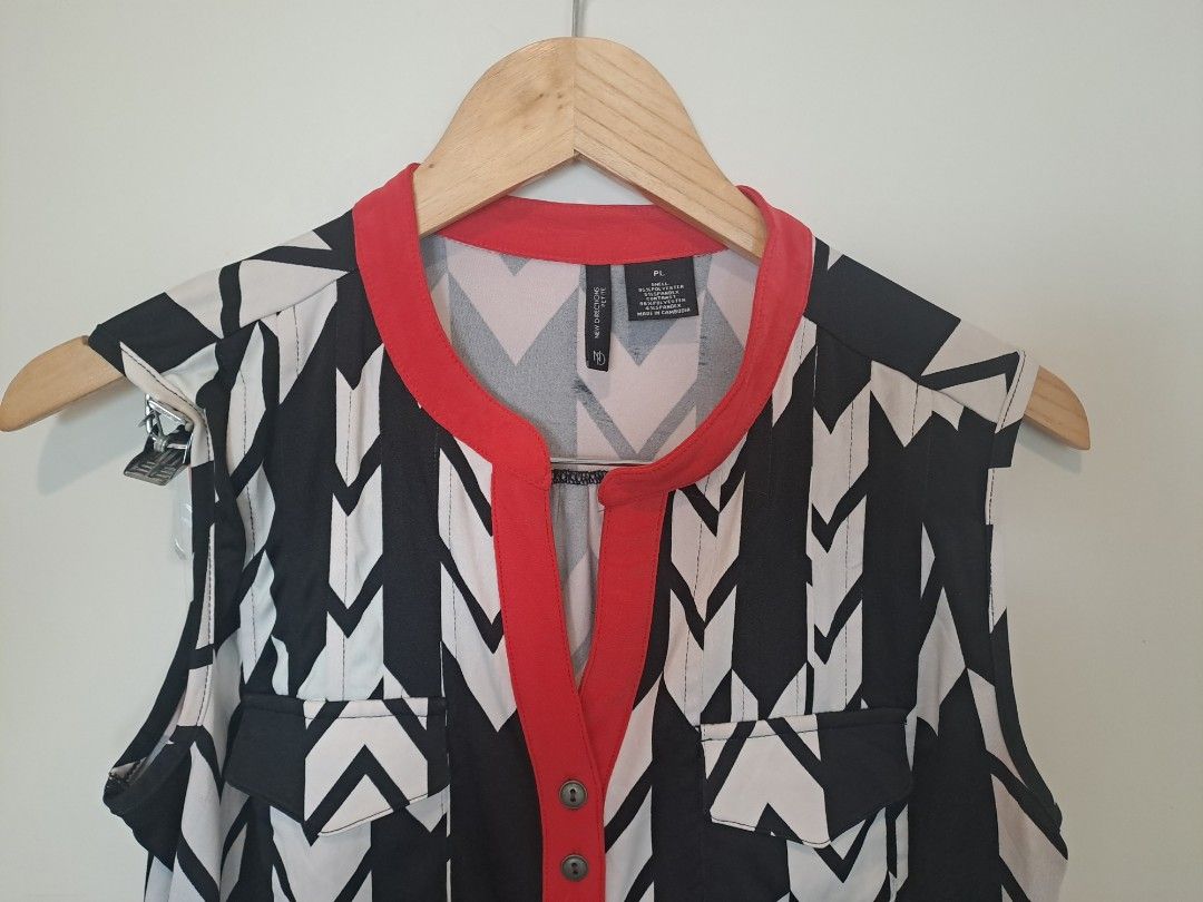 Black n white chevron (Category: Sleeveless) located in Manila. Submitted by joanbalde39643 (Listing ID 1466837371, Image 2). Description: This item is a New Directions Black and White Chevron Sleeveless Top with Red Trim. It features a bold, contrasting zigzag chevron pattern accented by two small chest flap pockets and a vibrant red mandarin-style collar and partial button placket..