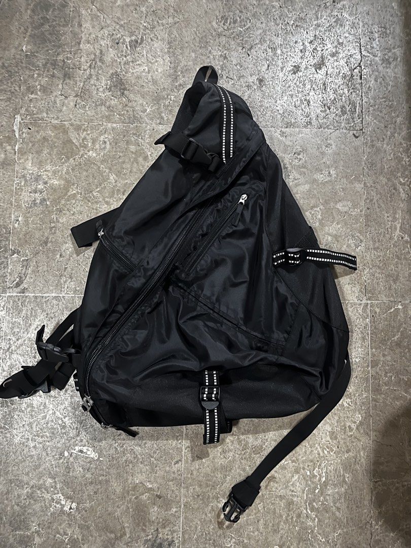 Black Sling Bag Crossbody Backpack (Category: Sling Bags) located in Zamboanga. Submitted by jajamwaa (Listing ID 1466858967, Image 1). Description: - Color: Black - Material: Durable nylon - Design: Triangular sling bag with stylish reflective patterned webbing on straps and bottom - Storage: Multiple zippered compartments for easy organization - Wearability: Adjustable straps, can be worn across the chest or back - Usage: Ideal hands-free every