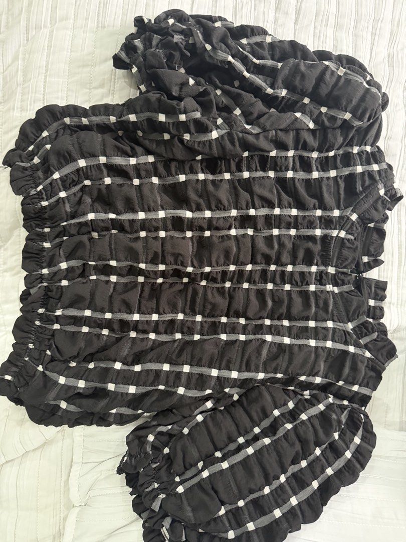 Black White Check Smocked Blouse Ruffle Trim Top (Category: Blouses) located in Quezon City. Submitted by afternoonstore (Listing ID 1466843855, Image 1). Description: - Color/Pattern: Black with all-over white checkered pattern - Fit & Feel: Fully smocked, highly stretchy, and lightweight fabric - Design Details: Ruffled neckline and hem, short puffy smocked sleeves - Style: Versatile everyday piece, easy to dress up or down.