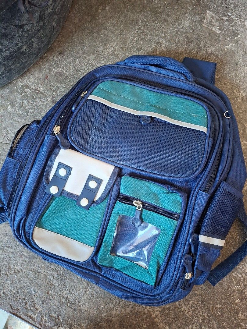 Blue and Green Multi-Pocket Backpack with Padded Straps (Category: Babies & Kids Fashion) located in Manila. Submitted by ethejampong (Listing ID 1466850603, Image 1). Description: brandnew po, never been used. Nakatambak lang din po dito kaya ibenta nalang Around 400-500 ang orig price neto - Color: Blue with vibrant green and white panel accents - Storage: Multiple front zipped compartments and a clear ID/card slot - Comfort: Ergonomic padded b