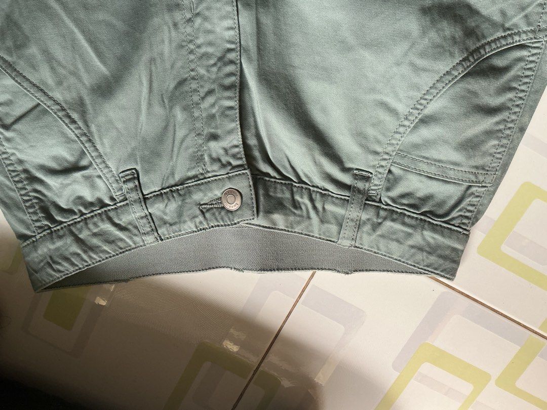 Bossini Green Cargo Pants (unisex) (Category: Jeans) located in Pasay City. Submitted by neighbourhoodfinds (Listing ID 1466836372, Image 2). Description: - Brand: Bossini - Size: 28-30 (175/72Y) Length: 38 - Color: Muted sage green - Fit: Relaxed loose fit with elasticated waistband detail - Material: Sturdy cotton twill - Features: Multiple utility pockets, front button closure, and belt loops - Style: Great for everyday casual streetwear.