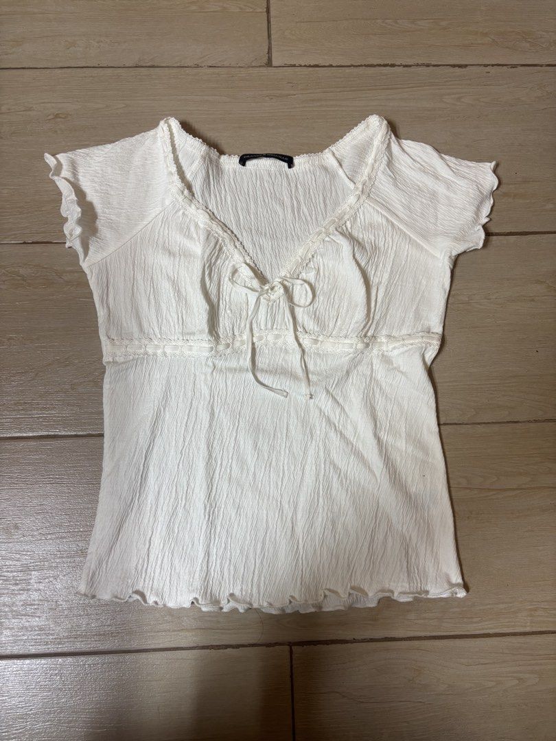 Brandy Melville White lani Top (Category: Blouses) located in Paranaque City. Submitted by preloved_archives (Listing ID 1466839136, Image 2). Description: - Brand: Brandy Melville - Color: White - Style: Crinkled textured short-sleeve top with V-neck and front tie - Bought but Never worn .