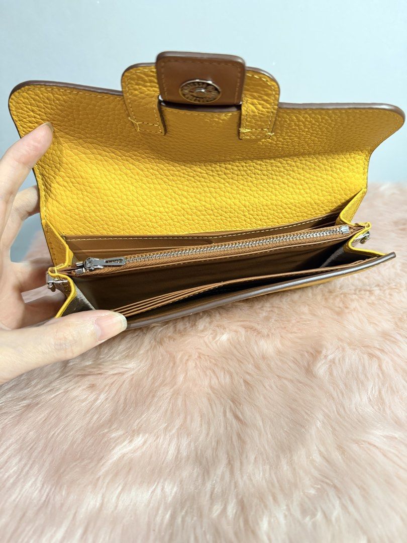 Bright Yellow Pebble Grain Leather Long Wallet (Category: Wallets & Card holders) located in Quezon City. Submitted by shaberbree (Listing ID 1466915199, Image 2). Description: - Color: Bright yellow with brown interior - Material: Pebble grain texture - Closure: Secure magnetic snap front flap - Storage: Multiple card slots and a center zippered coin compartment - Condition: Clean inside and out - Ideal for: Daily use or as a grab-and-go wallet 