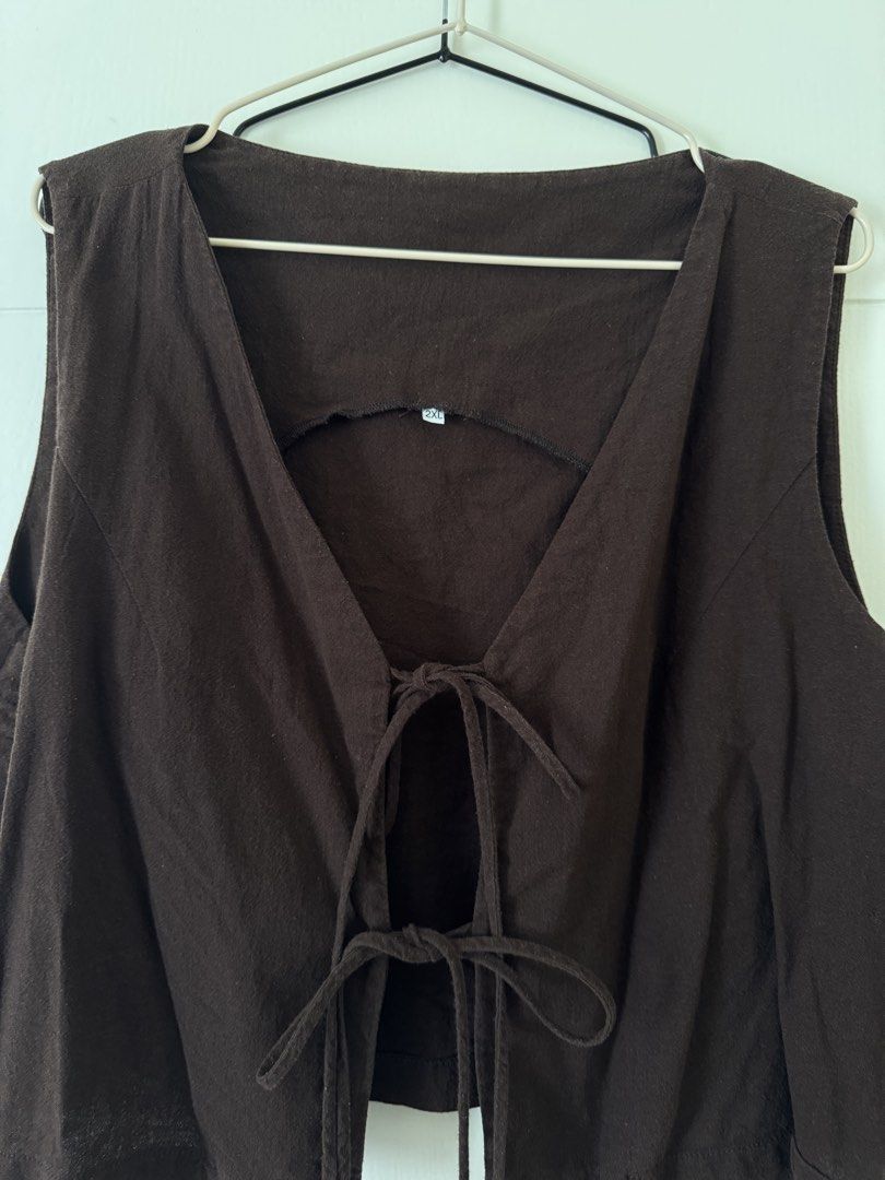 Brown tie-front crop vest top 2XL (Category: Sleeveless) located in Mandaluyong City. Submitted by trinket.ph (Listing ID 1466774933, Image 2). Description: - Color: Dark brown - Size: 2XL - Design: Deep V-neck, double front string ties, and back collar cutout - Material: Light and breathable fabric - Versatility: Perfect for layering over tees or wearing on its own - Condition: Good overall condition, no damage or stains.