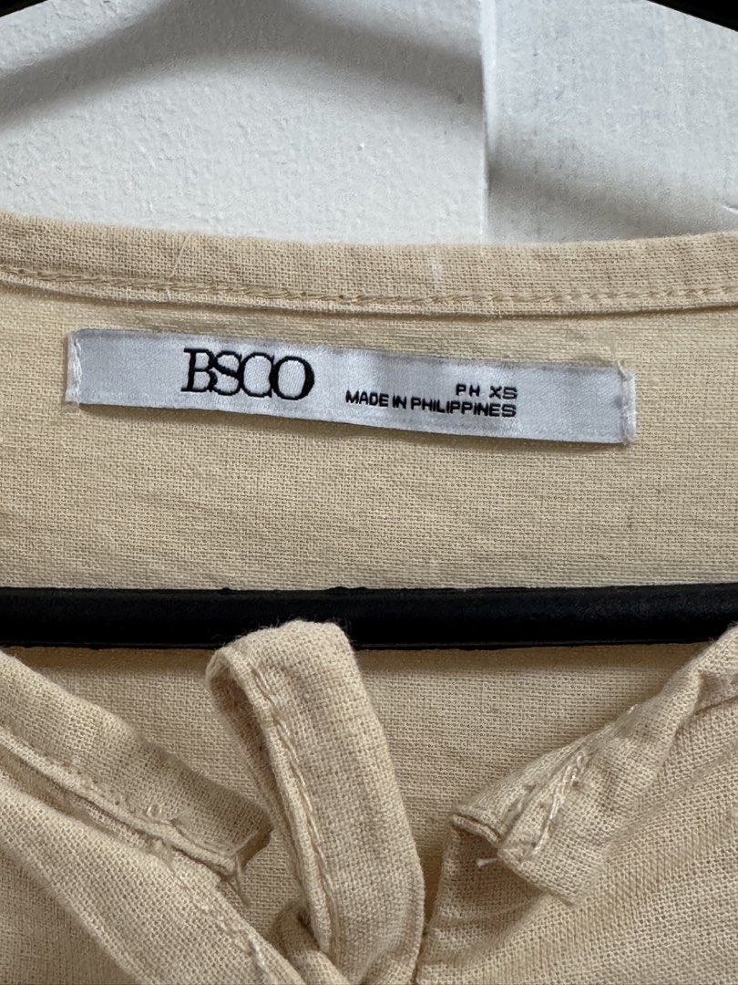 BSCO Beige Tied Peplum Blouse (Category: Blouses) located in Quezon City. Submitted by mikhaela.b (Listing ID 1466929466, Image 3). Description: - Brand: BSCO - Size: PH XS - Color: Neutral Beige (solid) - Design: Front tie closures, trendy puffed shoulders, and a waist-defining peplum hem - Origin: Made in the Philippines - Styling: Versatile piece that pairs effortlessly with jeans or skirts.