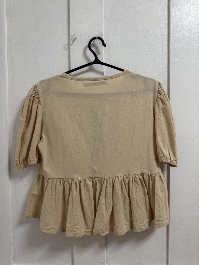 BSCO Beige Tied Peplum Blouse (Category: Blouses) located in Quezon City. Submitted by mikhaela.b (Listing ID 1466929466, Image 2). Description: - Brand: BSCO - Size: PH XS - Color: Neutral Beige (solid) - Design: Front tie closures, trendy puffed shoulders, and a waist-defining peplum hem - Origin: Made in the Philippines - Styling: Versatile piece that pairs effortlessly with jeans or skirts.