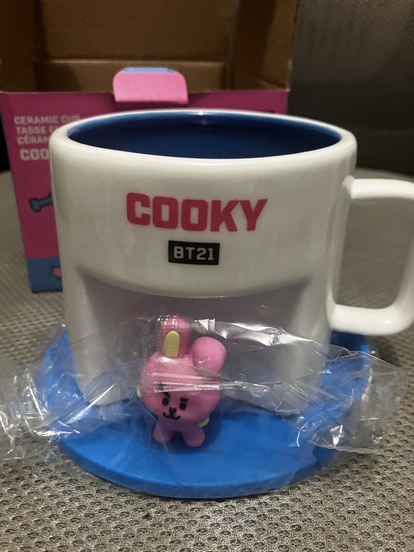 BT21 Cooky Ceramic Cup 450ml Line Friends (Category: Coffee & Tea Tableware) located in Manila. Submitted by yilviolet (Listing ID 1466963821, Image 2). Description: - Official LINE FRIENDS BT21 Cooky merchandise - Capacity: 450ml / 15.2 fl oz - Design: White exterior with bright pink Cooky text and contrasting blue interior - Inclusions: Comes with a small Cooky character figurine, blue base stand, and original printed box - Condition: Brand new