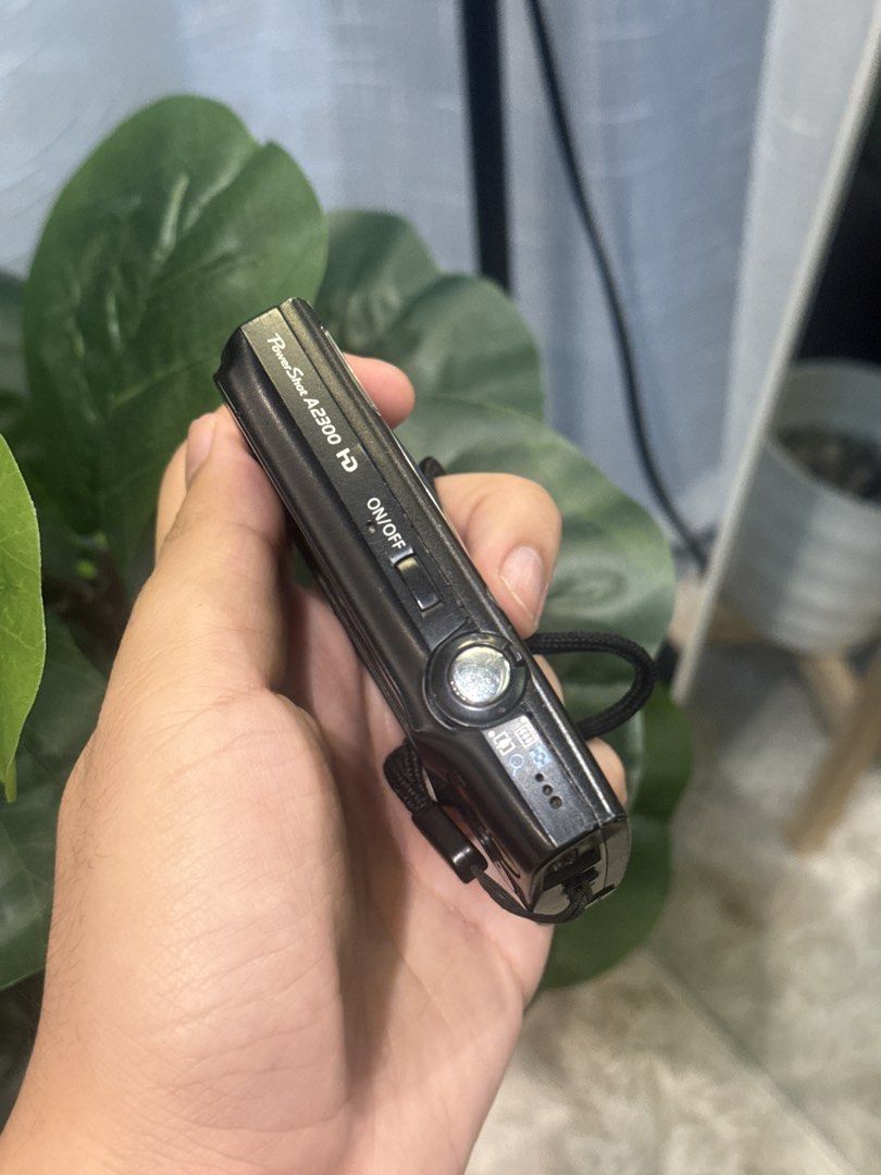 Canon PowerShot A2300 HD Digital Camera Black (Category: Cameras) located in Calamba. Submitted by leeadriannn796 (Listing ID 1466893362, Image 3). Description: Canon PowerShot A2300 HD digital camera in black. Compact 16.0 megapixel model with 5x optical zoom lens. Includes attached wrist strap. Standard buttons on the back and top on/off switch. Bottom tripod mount and battery compartment door. Pocket-sized point and shoot camera for casual pho