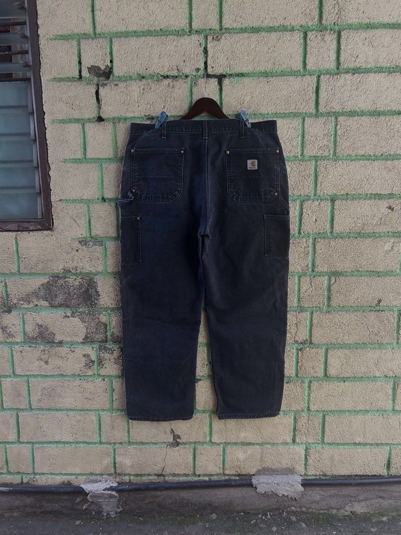 Carhartt Double Front Work Pants Black Made in USA (Category: Jeans) located in Bauan. Submitted by thrift.enough (Listing ID 1466803414, Image 2). Description: Black Carhartt double front work pants. Classic utility style with reinforced knees and multiple tool pockets. Hammer loop on the side. Made in the USA tag at the waistband. Heavy canvas material with a nice fade from wear. Back patch pocket with the Carhartt logo patch. Solid pair for wo