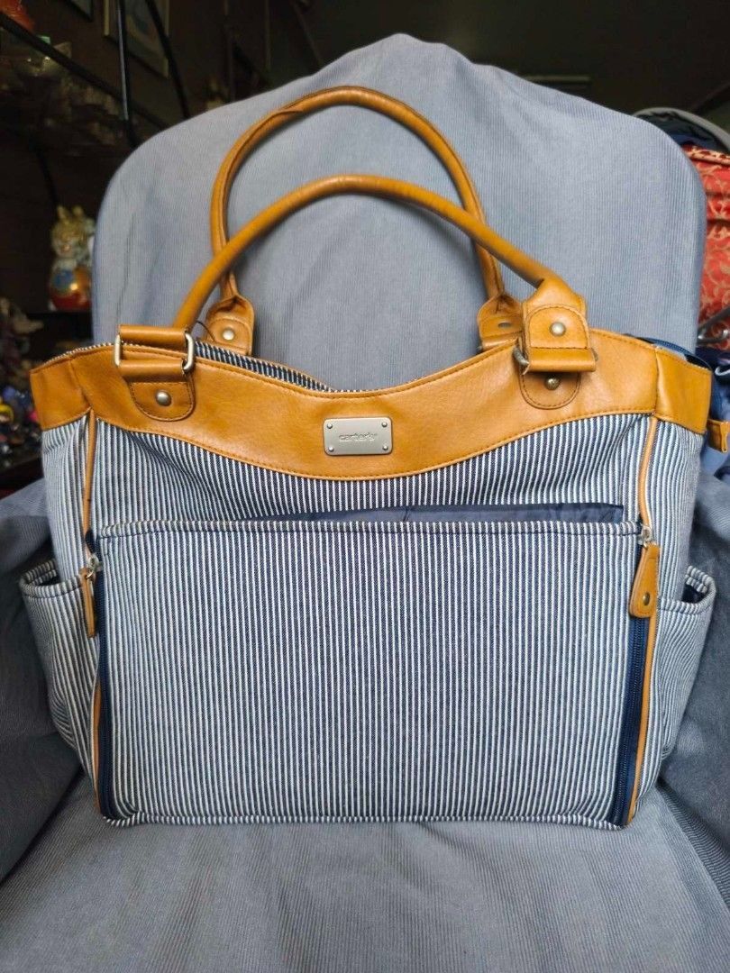 Carter's Baby Changing Bag (Category: Tote Bags) located in Pasig City. Submitted by rai_ph (Listing ID 1466801686, Image 1). Description: - Classic blue and white striped design with chic tan faux leather handles and trim - Secure large zippered front pocket and convenient side pockets for easy organization - Spacious interior ideal for daily essentials, work, or casual outings - Comfortable dual shoulder straps for easy carrying - Stylish silve
