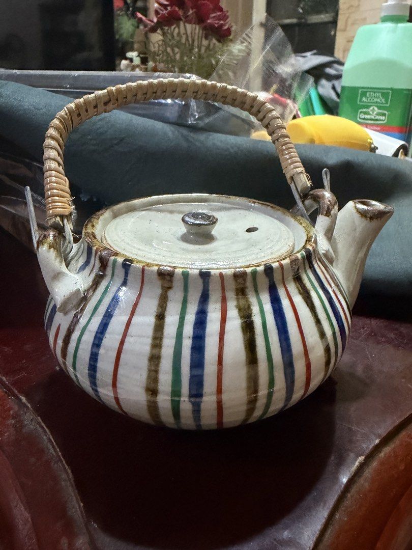 Ceramic Teapot with Woven Bamboo Handle and Striped Pattern (Category: Coffee & Tea Tableware) located in Manila. Submitted by lynnalec25 (Listing ID 1466814457, Image 2). Description: - Material: High-quality ceramic with a handmade aesthetic - Design: Colorful vertical stripes in blue, red, green, and brown - Features: Matching lid with steam vent, side spout, and a woven bamboo handle attached with metal brackets - Perfect for: Daily tea sessi