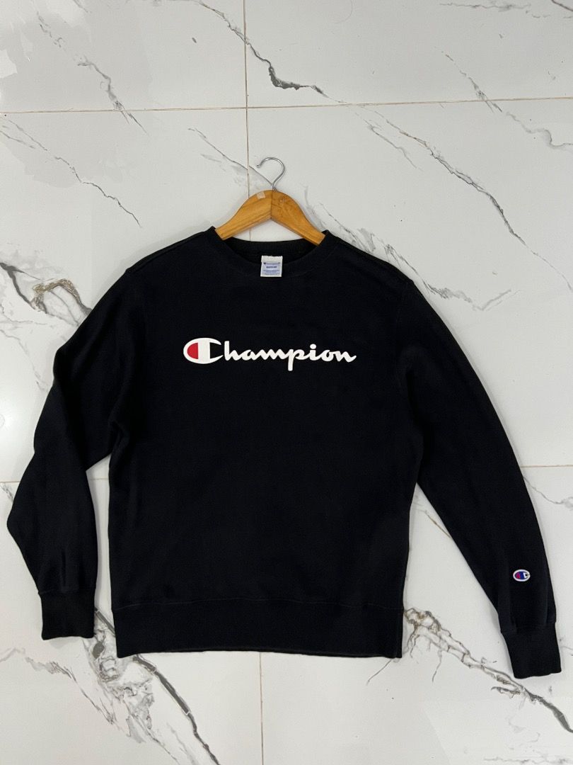 Champion Black Script Logo Sweatshirt Medium (Category: Coats, Jackets and Outerwear) located in Baguio. Submitted by pureearth.5f1c08 (Listing ID 1466901008, Image 1). Description: - Brand: Champion - Color: Black - Size: Medium - Design: White and red big script logo on chest, small embroidered 'C' logo patch on left sleeve cuff - Features: Ribbed collar, cuffs, and hem with a thick fleece interior - Condition: Clean shape and well maintained.