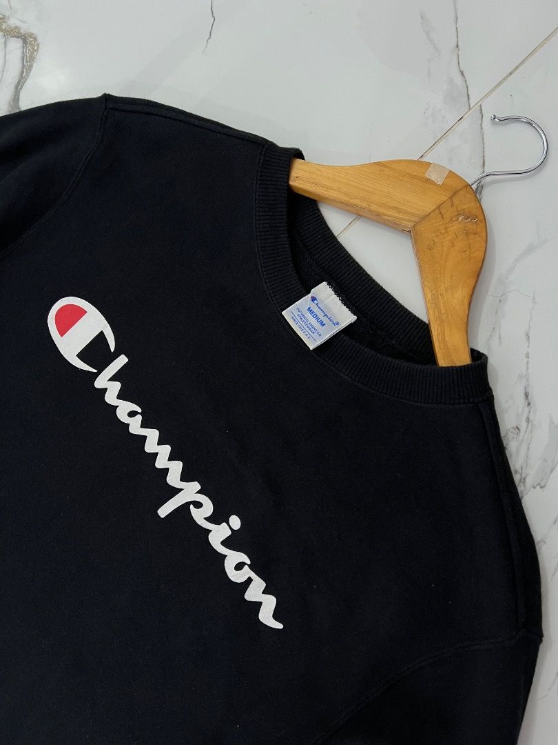 Champion Black Script Logo Sweatshirt Medium (Category: Coats, Jackets and Outerwear) located in Baguio. Submitted by pureearth.5f1c08 (Listing ID 1466901008, Image 2). Description: - Brand: Champion - Color: Black - Size: Medium - Design: White and red big script logo on chest, small embroidered 'C' logo patch on left sleeve cuff - Features: Ribbed collar, cuffs, and hem with a thick fleece interior - Condition: Clean shape and well maintained.