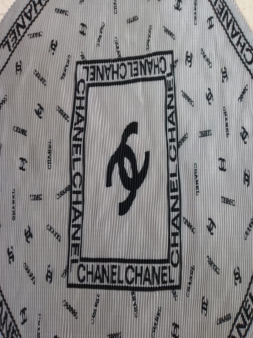 Chanel Pleated Scarf Grey Black CC Logo (Category: Luxury Accessories) located in Liloan. Submitted by dnznoon31 (Listing ID 1466858827, Image 2). Description: Grey pleated scarf with black Chanel lettering and CC logos all over. Features a large framed central box with a big CC logo inside. Soft pleated texture throughout. Can be worn around the neck or tied onto a bag handle. Great accessory for cooler weather. Dimensions 48 x 20 inches .
