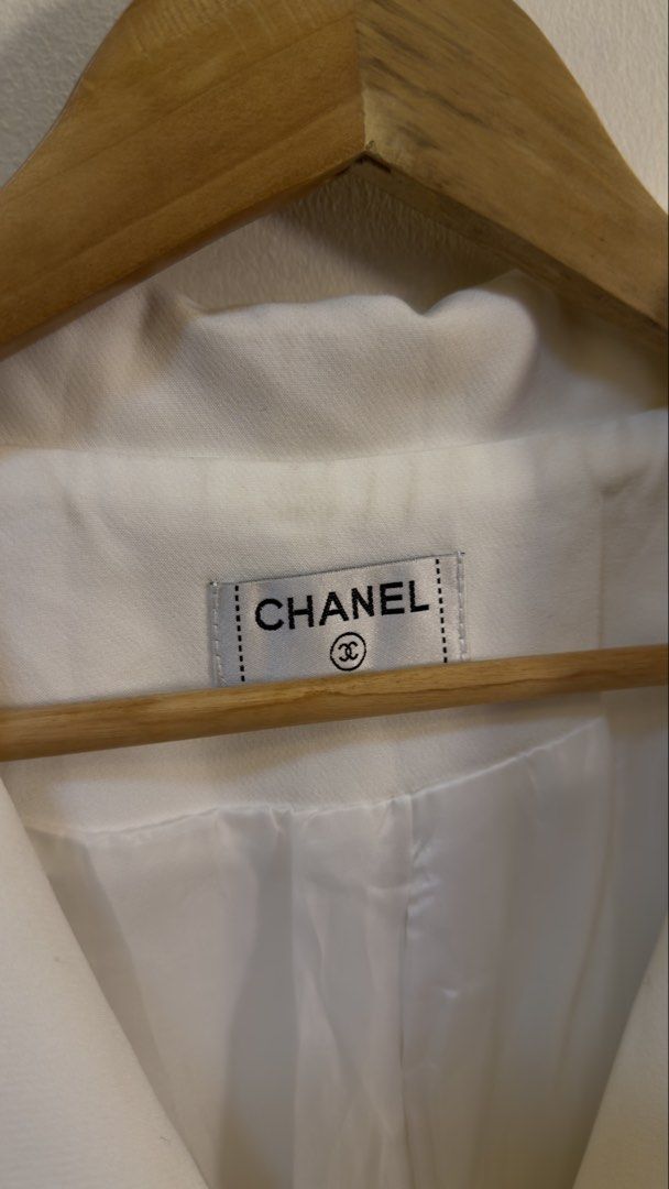 Chanel White Blazer with Black CC Logo Pocket (Category: Coats, Jackets and Outerwear) located in Paranaque City. Submitted by mykapoynton (Listing ID 1466958420, Image 3). Description: Chanel White Blazer with Black CC Logo Pocket - Design: Classic lapel collar with a two-button front closure - Pockets: Two functional front patch pockets - Interior: Fully lined with white fabric and features the official Chanel brand label at the back neck - Sle