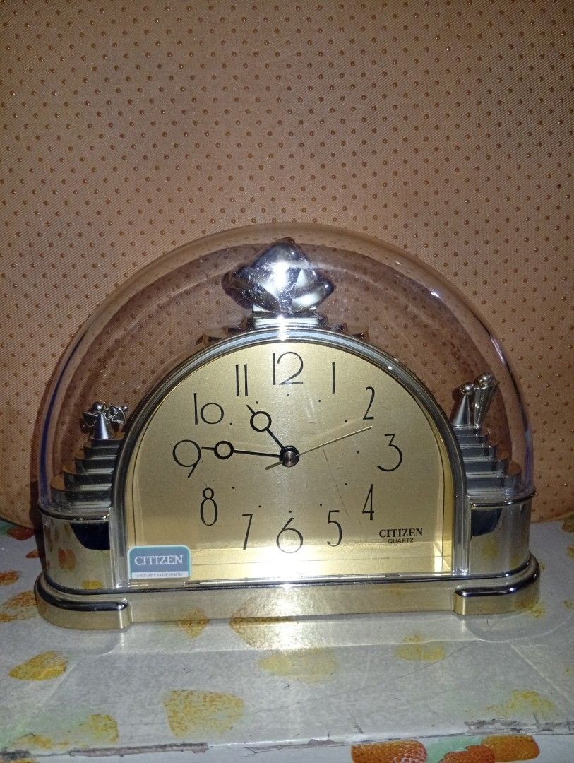 Citizen Quartz Arch Mantel Clock with Dome ( No Back Cover) (Category: Clocks) located in Davao. Submitted by lingxu23 (Listing ID 1466790946, Image 1). Description: - Authentic Citizen quartz arch mantel clock - Elegant gold-tone face with easy-to-read black numerals and classic hands - Clear protective dome cover topped with a decorative finial - Unique stepped design on both sides accented with small silver figurines - Battery-operated, ideal 