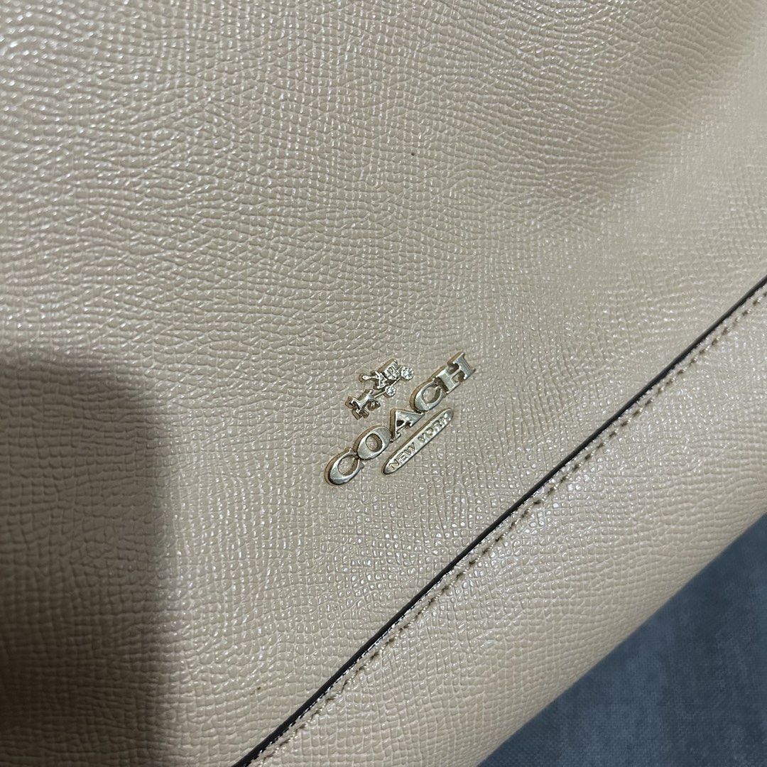 Coach Beige Leather Dome Satchel Bag (Category: Luxury Bags & Wallets) located in Taytay. Submitted by bealieber (Listing ID 1466881250, Image 2). Description: - Authentic Coach dome satchel in chic beige pebbled leather - Top zip closure with dual rolled handles and detachable shoulder strap (see pic for minor flaw) - Clean light brown fabric interior with slip pockets and zippered compartment - Includes signature Coach creed patch inside (faded