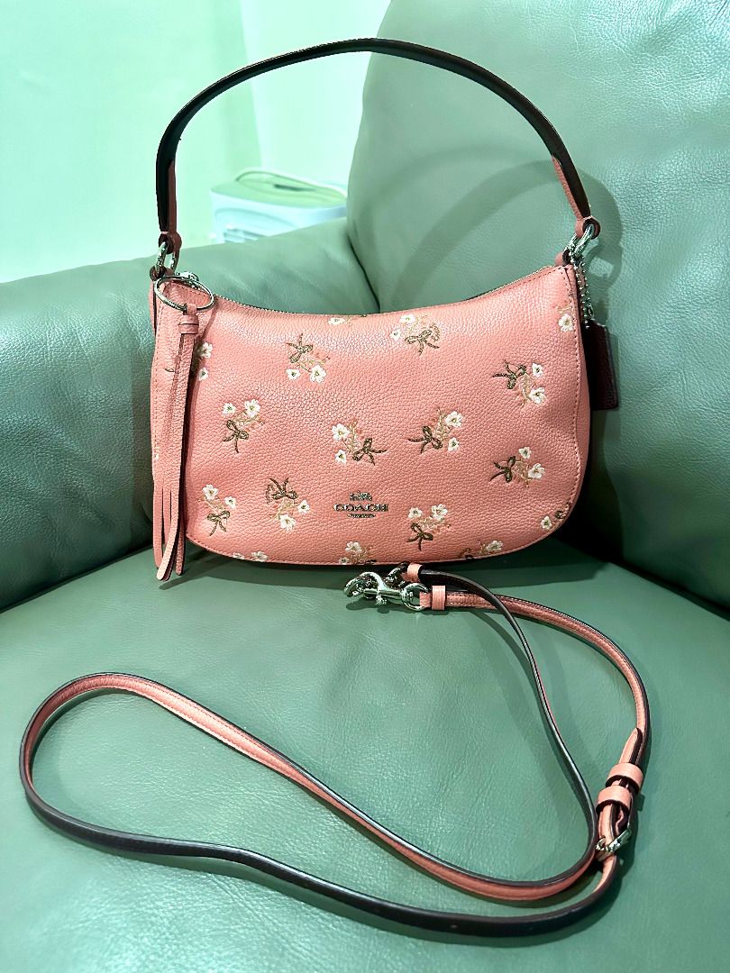 Coach Floral Bow Print Leather Shoulder Bag (Category: Luxury Bags & Wallets) located in Calamba. Submitted by clearoutbyc (Listing ID 1466833669, Image 2). Description: - Authentic Coach shoulder bag in pink pebble leather - Features cute embroidered floral and bow motifs - Silver-tone hardware with Coach New York front logo - Secure zip-top closure with a clean interior and exterior - Versatile design includes a short handle, detachable tassel 
