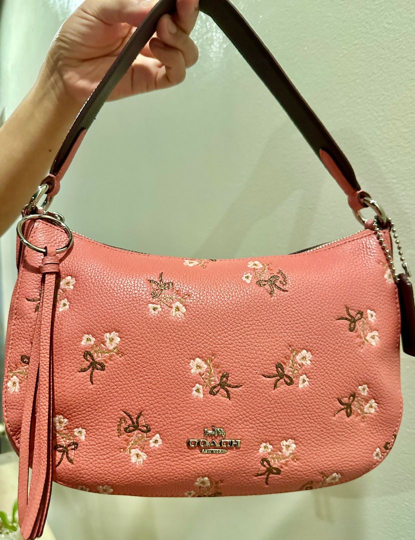 Coach Floral Bow Print Leather Shoulder Bag (Category: Luxury Bags & Wallets) located in Calamba. Submitted by clearoutbyc (Listing ID 1466833669, Image 3). Description: - Authentic Coach shoulder bag in pink pebble leather - Features cute embroidered floral and bow motifs - Silver-tone hardware with Coach New York front logo - Secure zip-top closure with a clean interior and exterior - Versatile design includes a short handle, detachable tassel 
