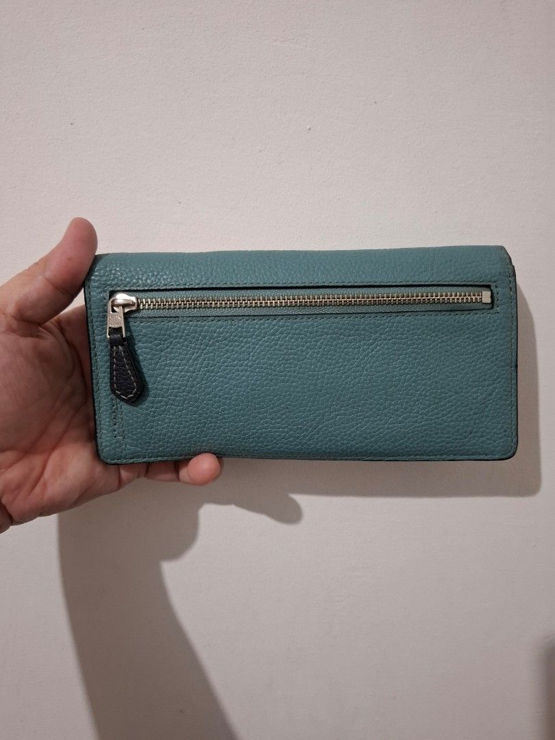 Coach Leather Long Wallet Turquoise Blue (Category: Wallets & Card holders) located in Bacolod City. Submitted by asheroth77 (Listing ID 1466783990, Image 2). Description: Turquoise blue Coach long wallet in pebbled leather. Silver-tone hardware and front logo lettering. Zip pocket on the back side. Black leather interior lining with multiple card slots and cash compartments. Snap button closure to keep everything secure. Practical everyday acces