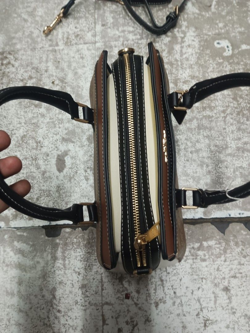 Coach Mini Darcie Carryall Colorblock (Category: Cross-body Bags) located in Baguio. Submitted by brandeditems16 (Listing ID 1466965104, Image 2). Description: - Brand: Coach - Design: Signature monogram print with chic black and brown leather panels - Hardware: Premium gold-tone accents throughout - Versatility: Features dual top handles and a convenient detachable shoulder strap - Closure: Secure zip-top closure - Interior: Clean dark fabric li