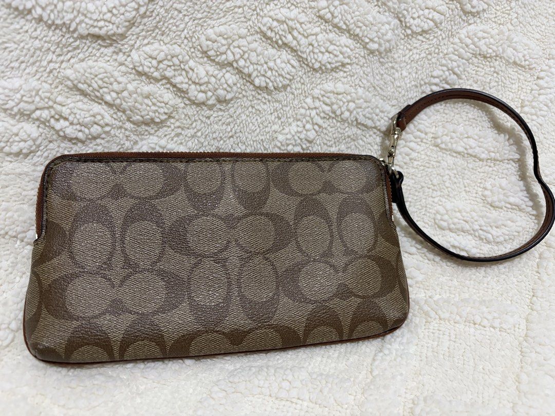 Coach Signature Canvas Double Zip Wristlet (Category: Luxury Bags & Wallets) located in Paranaque City. Submitted by greatfinds108 (Listing ID 1466811945, Image 2). Description: - Brand: Coach - Material: Signature canvas with smooth brown leather center stripe - Hardware: Gold-tone - Compartments: Dual zippered sections for phone, cards, and cash - Interior: Brown fabric lining with multiple card slots and slip pockets - Extras: Includes a conve